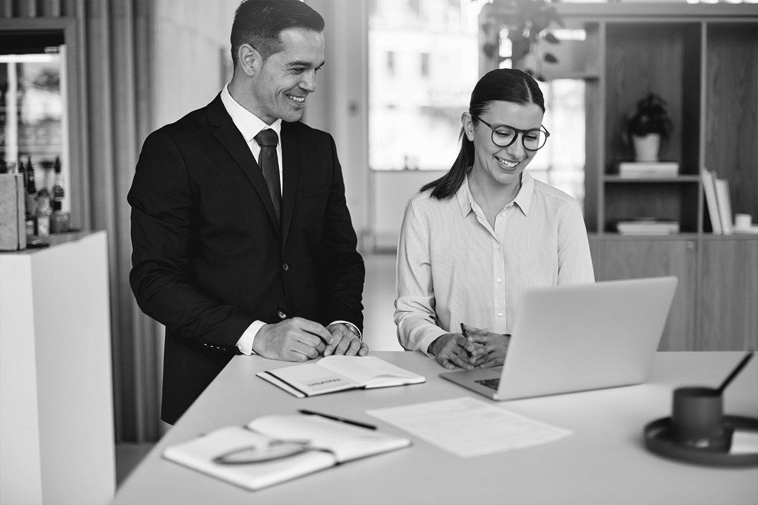 two-smiling-businesspeople-working-together-in-an-2021-08-26-17-26-59-utc-BW